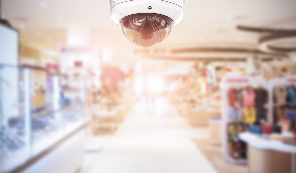 Bullet camera with mall atmosphere blurred in background